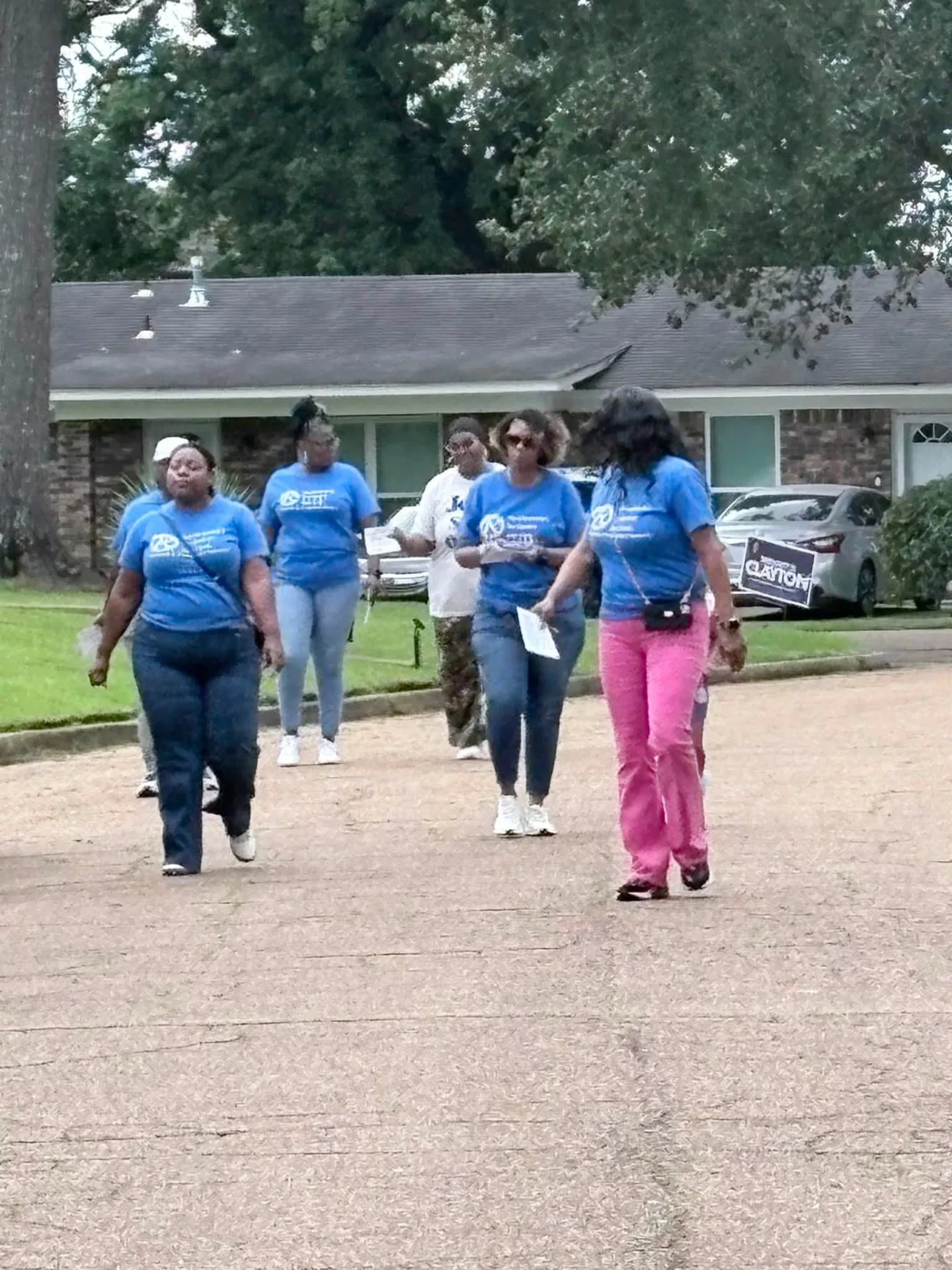 REC members in church t-shirts walking a Jackson neighborhood during outreach