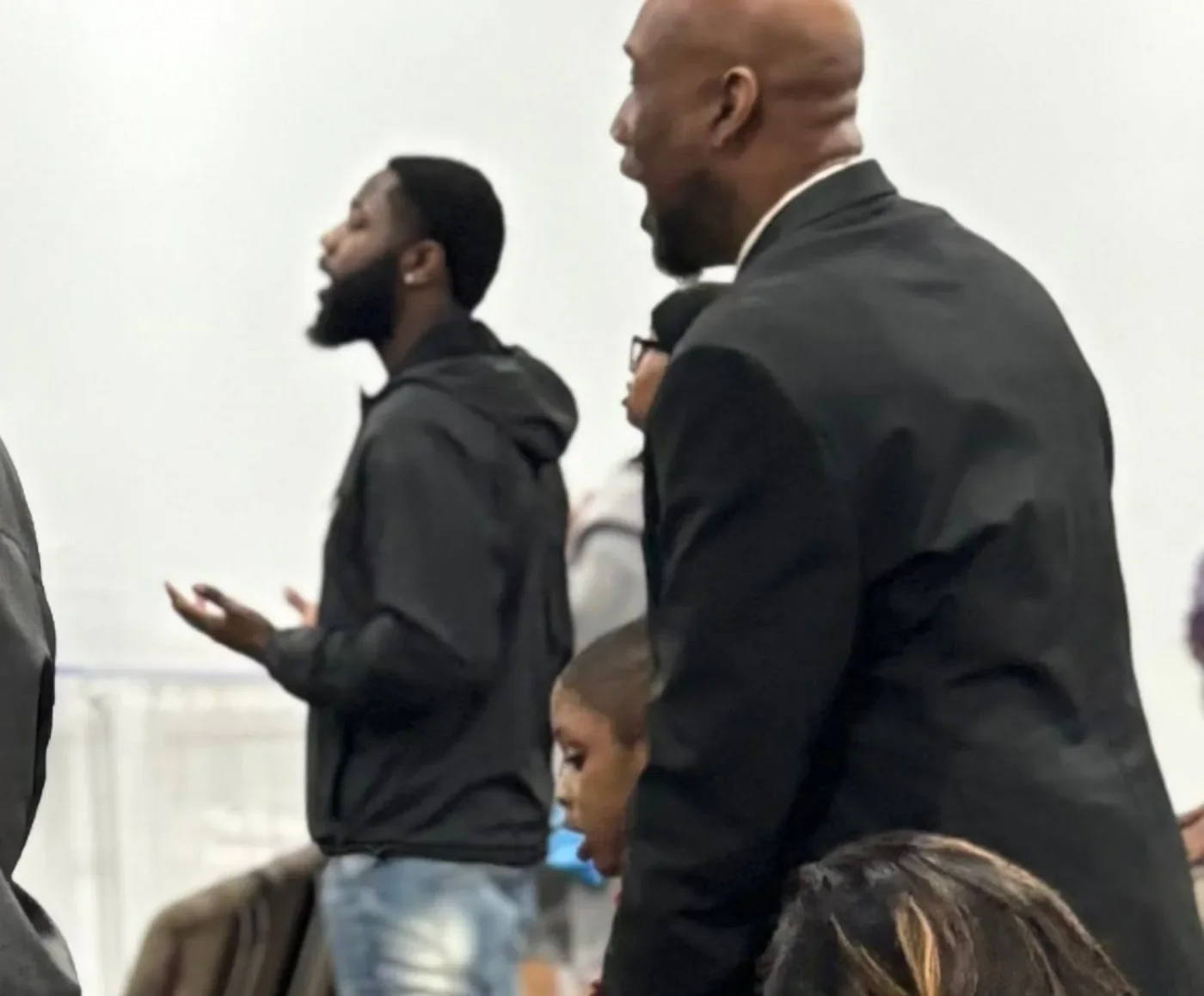 REC members standing with hands raised in worship during a Sunday service